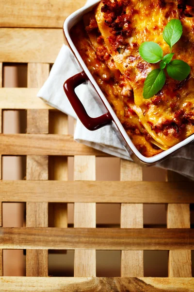 Comida italiana. Placa de lasaña sobre mesa de madera . — Foto de Stock