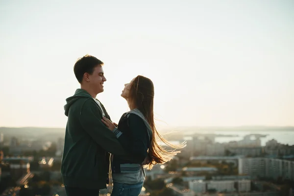 Joven pareja elegante abrazándose en el techo — Foto de Stock