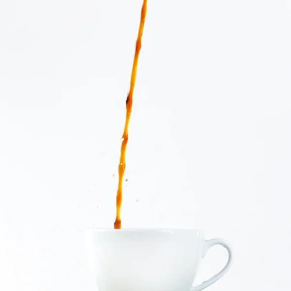 Gieten koffie in een cup op witte achtergrond. Ontbijt. — Stockfoto