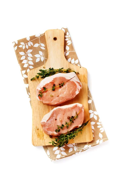 Fresh raw pork steaks on cutting board — Stock Photo, Image