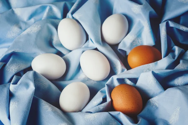 Πασχαλινά αυγά σε μπλε κλωστοϋφαντουργικών ντυμένο φόντο — Φωτογραφία Αρχείου