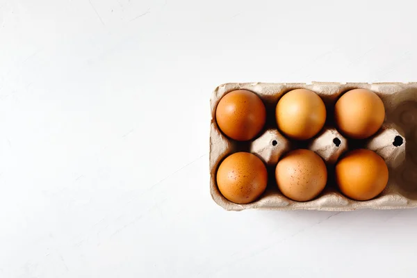 Ägg i paketet på vit bakgrund — Stockfoto