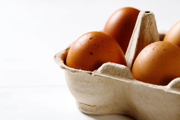 Huevos en el paquete sobre fondo blanco —  Fotos de Stock