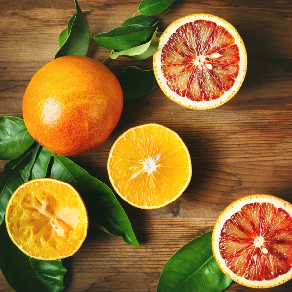 Different sort of orange fruit on wooden table — Stock Photo, Image