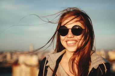 Eğleniyor yuvarlak güneş gözlüklü genç kadın 