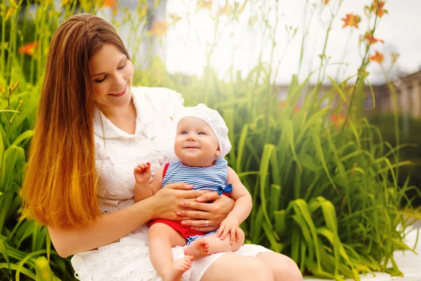 Bebê bonito da criança sentado em mãos da mãe — Fotografia de Stock