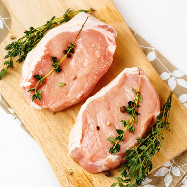 Bistecche fresche di carne di maiale cruda con erbe — Foto Stock