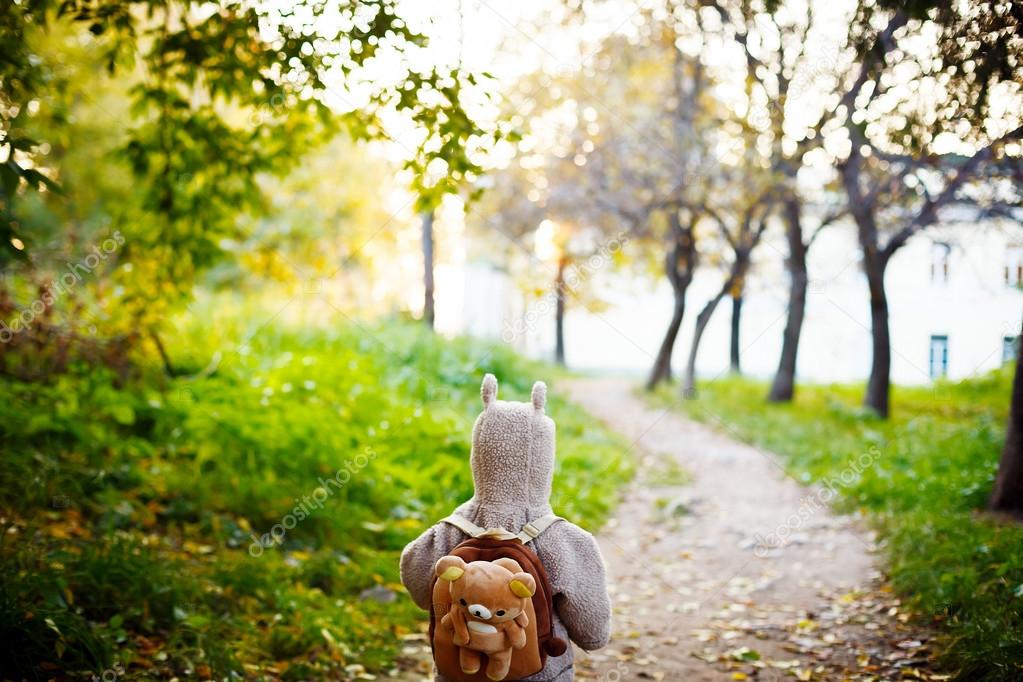 Little Kid in Funny Jacket Walking in the Park