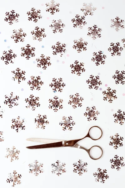 Par de tijeras entre copos de nieve de plata —  Fotos de Stock