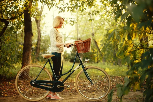 Mujer montando en bicicleta vintage con cesta — Foto de Stock