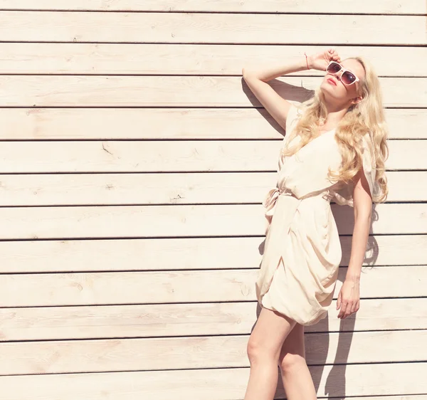 Verano al aire libre sensual retrato de moda hermosa joven rubia un vestido blanco de pie sobre el fondo de tablones de madera. Tonificado en colores cálidos —  Fotos de Stock