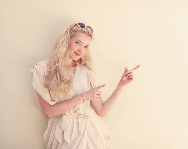 Summer portrait of young beautiful blond woman in white dress posing near the wall and have fun. Toned in warm colors — Stock Photo, Image