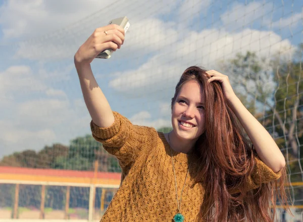 Beautiful redheaded girl doing a selfie outdoor — Stock Photo, Image