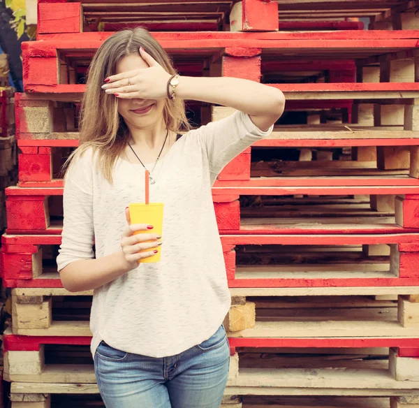 Beautiful blonde girl closes her eyes stands near the wooden racks. Outdoor — Stock Photo, Image