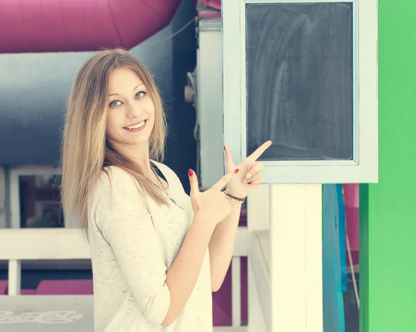 Beautiful blonde girl showing thumbs up on a board outdoor — Stock Photo, Image