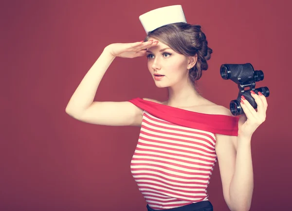 Vintage bir dürbün ile güzel kız denizci ve mesafe içine görünüyor — Stok fotoğraf