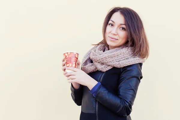 Bella ragazza bruna in posa in autunno con un bicchiere in mano. Chiudete. All'aperto — Foto Stock