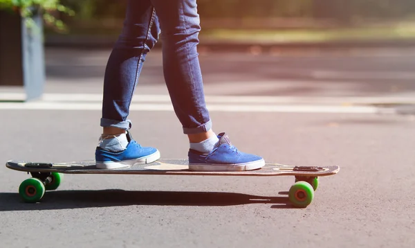 Longboard dziewczyna na ulicy w piękny letni poranek. Tonie w ciepłych kolorach. — Zdjęcie stockowe