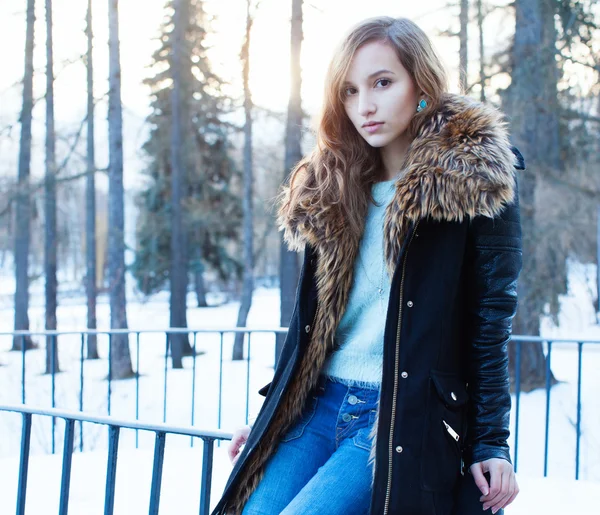 Sunny winter portrait of a beautiful girl in a jacket with a fashionable bag — Stock Photo, Image