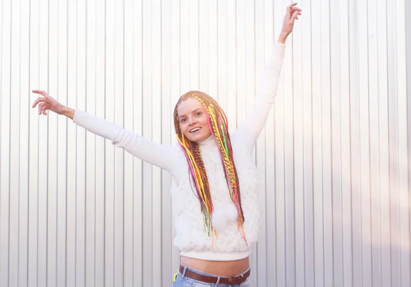 Mooi meisje met dreadlocks zonnige zomerdag poseren in de buurt van de muur pret buiten — Stockfoto