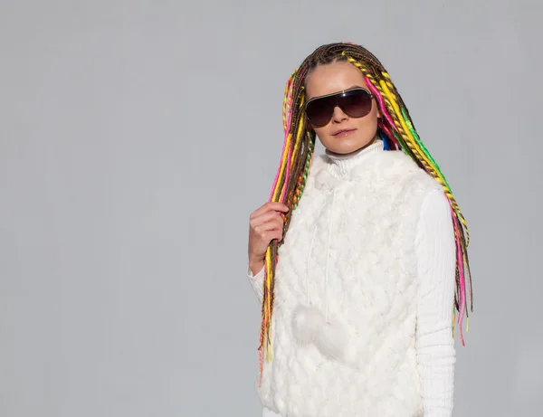 Belle fille avec dreadlocks ensoleillé journée d'été dans les lunettes de soleil posant près du mur amusant — Photo