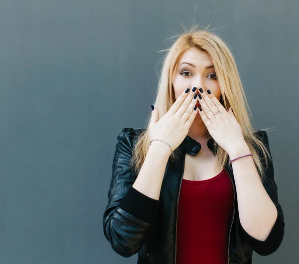 Portréja egy fiatal, gyönyörű szőke lány bezárja száj kezét meglepetés — Stock Fotó