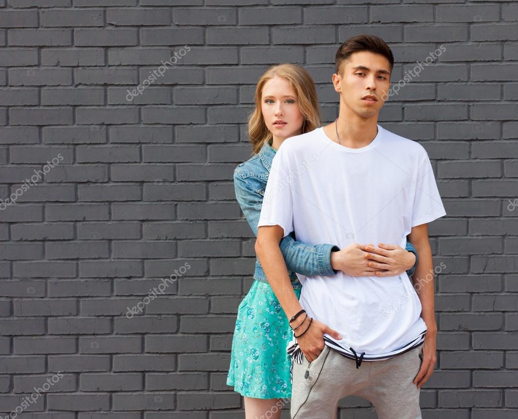 Interracial young couple in love outdoor. Stunning sensual outdoor portrait of young stylish fashion couple posing in summer