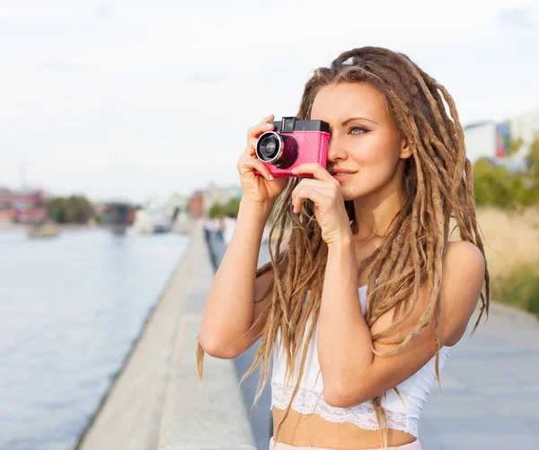 Trendi lány retteg és Vintage kamera állandó a folyó portréja. Modern ifjúsági életmód fogalma. A kép. — Stock Fotó