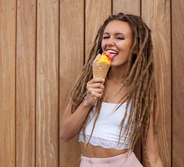 Menina loira sexy nova com dreads comer sorvete multicolorido em cones waffle na noite de verão, alegre e alegre . — Fotografia de Stock