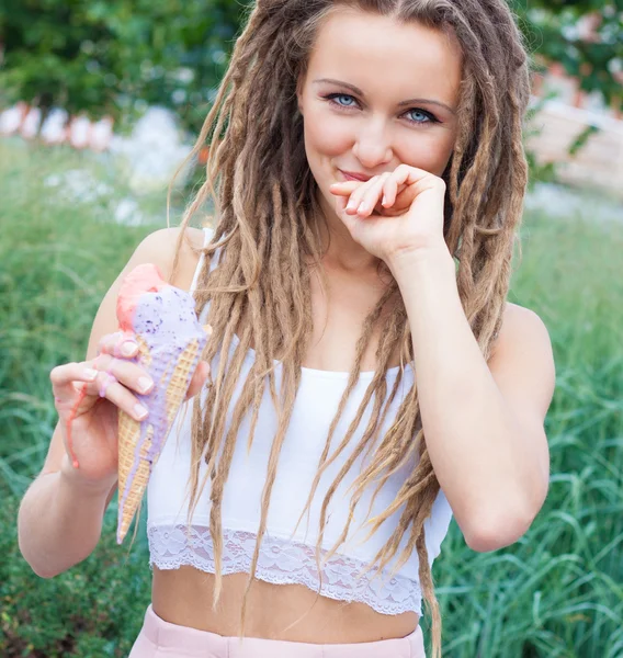 Joven chica rubia sexy con temores comiendo helado multicolor en conos de gofre en la noche de verano, alegre y alegre. Centro de la ciudad europea, en el parque. De cerca. . — Foto de Stock