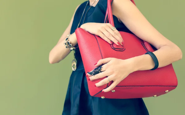Модная красивая большая красная сумочка на плече девушки в черном платье. Теплые цвета — стоковое фото