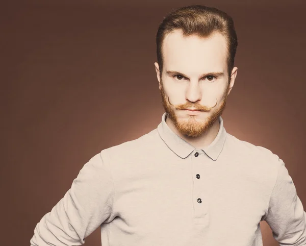 Portrait of a young man with a mustache and beard jeans and plaid shirt hipster style in the studio. Close up. Toned color — Stock Photo, Image