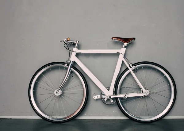 Mocowanych na piękny starodawny rower stoi szary tło — Zdjęcie stockowe