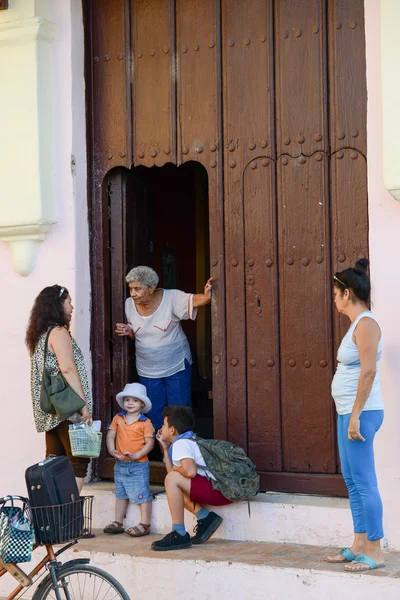 Gente hablando delante de una puerta de entrada —  Fotos de Stock