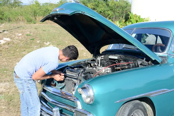남자 repiring Santiago de 쿠바에 그의 빈티지 자동차 — 스톡 사진