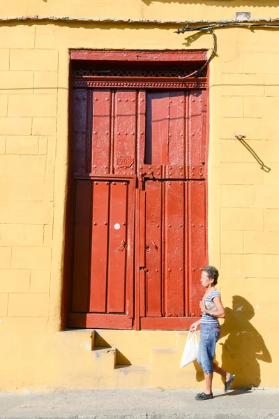 Mulher wolking na frente de uma velha porta de madeira — Fotografia de Stock