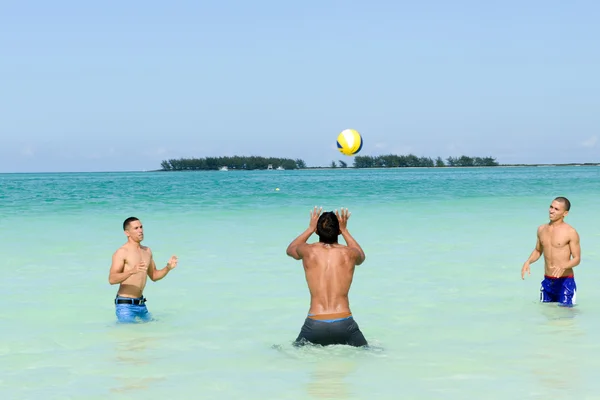 Люди играют в волейбол в чистой воде пляжа Кайо Гильермо — стоковое фото