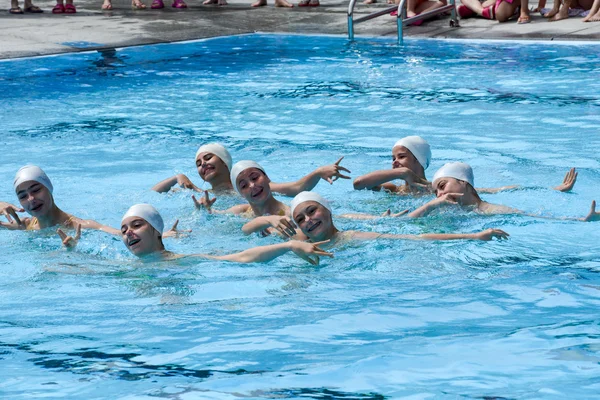 Grupo de chicas en una piscina practicando natación sincronizada — Foto de Stock