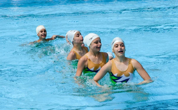 Grupo de chicas en una piscina practicando natación sincronizada — Foto de Stock