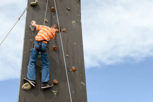 Effort d'un garçon en escaladant un mur — Photo