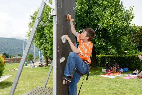 Effort d'un garçon en escaladant un mur — Photo