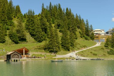 Engelberg, İsviçre - 8 Ağustos 2020: İsviçre Alplerinde Engelberg 'in yukarısındaki Truebsee Gölü' nde sandallarında kürek çeken turistler