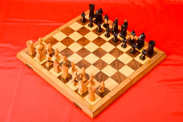 Schackbräde på röd bakgrund — Stockfoto