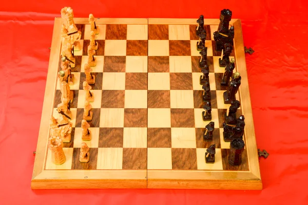 Schackbräde på röd bakgrund — Stockfoto
