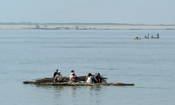 Mensen op een vlot met hout cruise op de rivier Ayeyarwady — Stockfoto