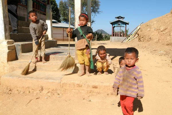 Les enfants se tiennent pieds nus devant leur maison familiale — Photo