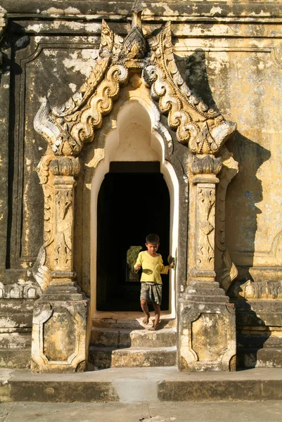 Boy walking out the door of Maha Aungmye Bonzan Monastery at Inw — Stock Photo, Image