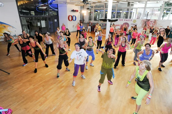 Gente bailando durante el entrenamiento de Zumba fitness en un gimnasio —  Fotos de Stock