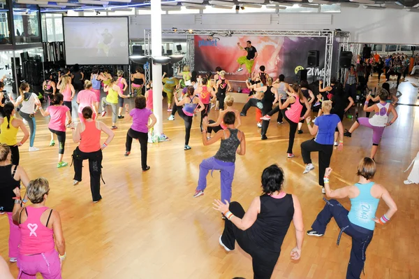 Les gens dansent pendant l'entraînement de Zumba fitness dans une salle de gym — Photo