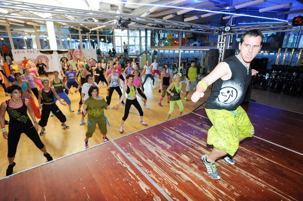 Gente bailando durante el entrenamiento de Zumba fitness en un gimnasio — Foto de Stock